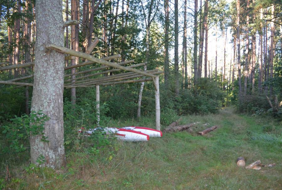 Каркас хозпостройки у беседки и запас дров.